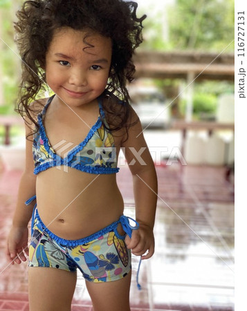 Portrait of a cute little girl in swimsuit at swimming pool 116727131