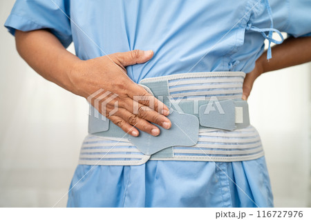 Asian lady patient wearing back pain support belt for orthopedic lumbar with walker. 116727976