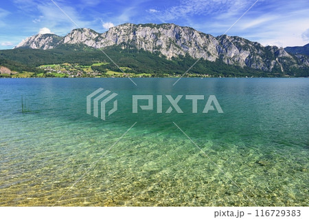 Attersee - a beautiful blue lake in Austria. Surrounded by mountains and green forests. Regions with nature in the Alps. A great place for sports, recreation and outdoor activity holidays. Attersee - a beautiful blue lake in Austria. Surrounded by mountains and green forests. Regions with nature in the Alps. A great place for sports, recreation and outdoor activity holidays. 116729383