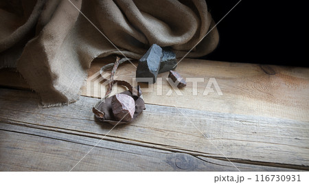 An antique leather sling lies on wooden desk An antique leather sling lies on wooden desk 116730931