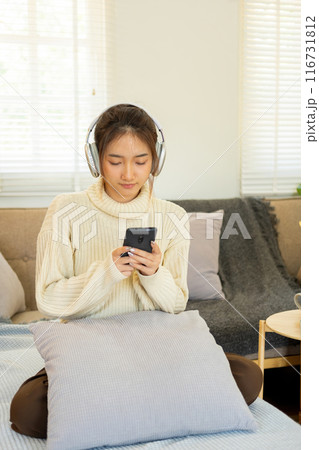 Woman listening to music for relaxation on the couch. 116731812