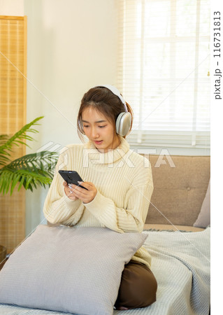Woman listening to music for relaxation on the couch. 116731813