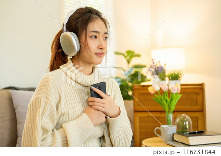 Woman listening to music for relaxation on the couch. 116731844