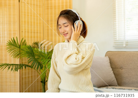 Woman listening to music for relaxation on the couch. Woman listening to music for relaxation on the couch. 116731935