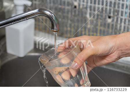 水道水をコップに注いでいる 水道水を飲むことへの安全性 水道水をコップに注いでいる 水道水を飲むことへの安全性 116733229