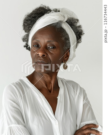 A mature woman's portrait, wrapped in white, showcases timeless wisdom. Her headscarf and earrings speak of a life rich with stories. 116734443