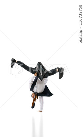 Life-work balance. Breakdancer in formal attire performs one-handed handstand, balancing with briefcase against white background. 116735759