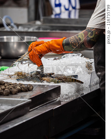 Person Arranging Fresh Seafood on Ice at a Market Person Arranging Fresh Seafood on Ice at a Market 116735799