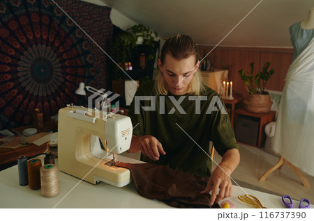 Tailor Sewing Clothing In Workshop 116737390
