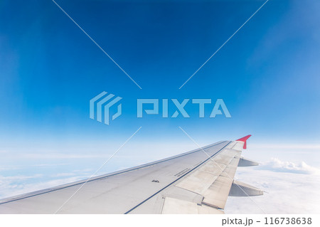 View from the airplane window at a beautiful cloudy sky and the airplane wing 116738638
