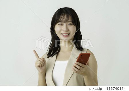 白背景のスマホで手にポーズをする若いビジネスウーマンのポートレート 116740134