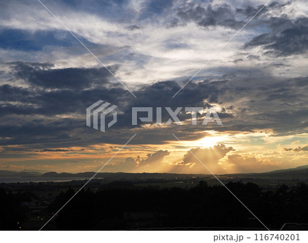 猪苗代湖上空の雲の切れ間から放射状の夕日が積乱雲を照らし、オレンジ色に輝かせる。印象的で綺麗だ。 猪苗代湖上空の雲の切れ間から放射状の夕日が積乱雲を照らし、オレンジ色に輝かせる。印象的で綺麗だ。 116740201