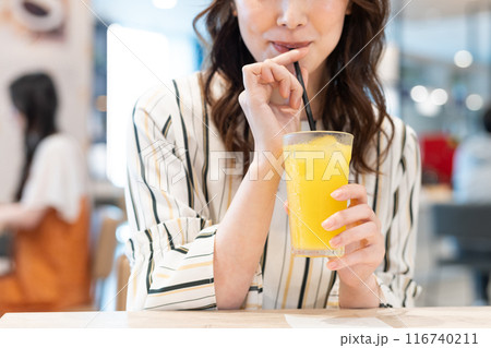 カフェでオレンジジュースを飲むミドルの女性　撮影協力：Creadisce（丸善雄松堂株式会社） 116740211