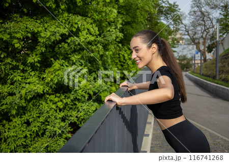 Fitness woman doing sport exercises enjoying outdoor workout in park 116741268