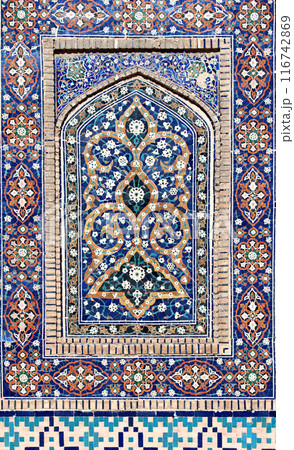 Vertical background with detail of ancient mosaic walls with floral and geometric ornament. Traditional tile decoration on wall, Bukhara, Uzbekistan 116742869