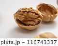 Close-up of Walnuts, Halved, in Shells on a White Background 116743337