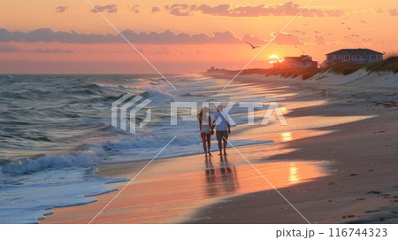 Romantic scene of a couple walking hand in hand along a serene beach at sunset, with soft waves lapping at their feet 116744323