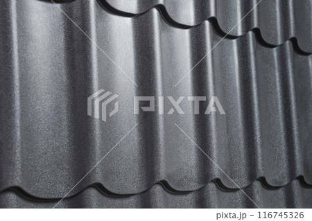 Close-up view lightweight galvanised steel roofing sheet. Modular tile effect roof panel. Traditional metal shingle tiles. Popular profiled metallic pantile mimic clay or concrete slate 116745326