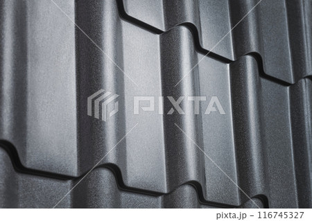 Close-up view lightweight galvanised steel roofing sheet. Modular tile effect roof panel. Traditional metal shingle tiles. Popular profiled metallic pantile mimic clay or concrete slate Close-up view lightweight galvanised steel roofing sheet. Modular tile effect roof panel. Traditional metal shingle tiles. Popular profiled metallic pantile mimic clay or concrete slate 116745327