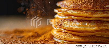A stack of golden brown pancakes with cinnamon sugar sprinkled on top. 116745783