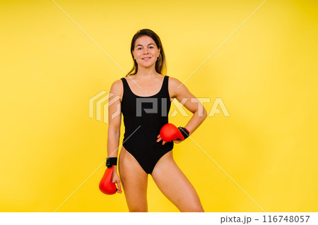 Strong sportswoman in boxing gloves prepared high kick. Isolated on white, red, yellow background Strong sportswoman in boxing gloves prepared high kick. Isolated on white, red, yellow background 116748057