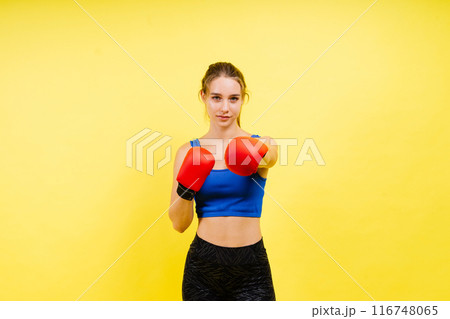 Young tired woman in sportswear and boxing gloves standing isolated on white yellow background. 116748065