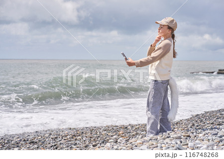 A quadrobra girl takes a selfie on the seashore. The concept of entertainment where children dress up as animals and combine it with gymnastic exercises. High quality photo A quadrobra girl takes a selfie on the seashore. The concept of entertainment where children dress up as animals and combine it with gymnastic exercises. High quality photo 116748268
