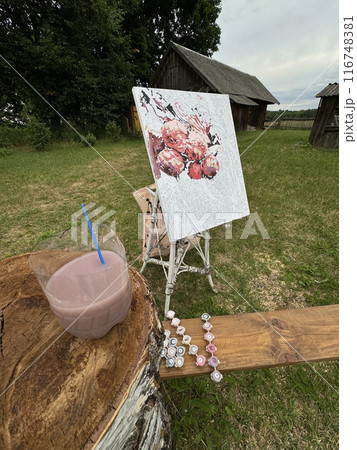 Rication for drawing by numbers on a stand. Paints in numbered jars and a can of water. Lying on a wooden bench. On open air. Rication for drawing by numbers on a stand. Paints in numbered jars and a can of water. Lying on a wooden bench. On open air. 116748381