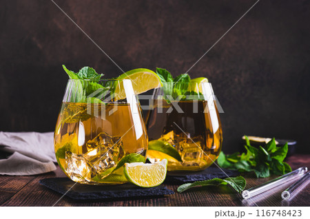 Refreshing iced tea with mint and lime in glasses on the table 116748423