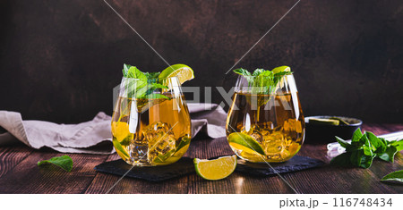 Refreshing iced tea with mint and lime in glasses on the table web banner 116748434