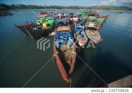 Ships transporting goods and people wait for passengers at the pier of Ngapali Beach Village. It is located on the coast of the Bay of Bengal in Rakhine State. Ships transporting goods and people wait for passengers at the pier of Ngapali Beach Village. It is located on the coast of the Bay of Bengal in Rakhine State. 116750926