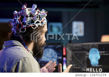 Software developer using EEG headset device translating thoughts into PC commands using brainwave signals. IT professional controlling computer functions using mind, helped by technology, close up Software developer using EEG headset device translating thoughts into PC commands using brainwave signals. IT professional controlling computer functions using mind, helped by technology, close up 116751174