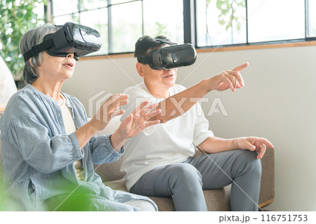 VRゴーグルをつけてバーチャルリアリティ・メタバースを体験するシニア世代の夫婦 116751753