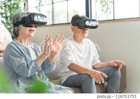 VRゴーグルをつけてバーチャルリアリティ・メタバースを体験するシニア世代の夫婦 116751755