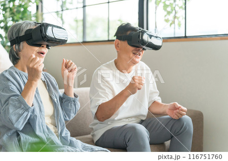 VRゴーグルをつけてバーチャルリアリティ・メタバースを体験するシニア世代の夫婦 VRゴーグルをつけてバーチャルリアリティ・メタバースを体験するシニア世代の夫婦 116751760