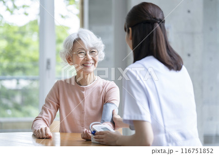 看護師に血圧を測ってもらうシニア女性 116751852