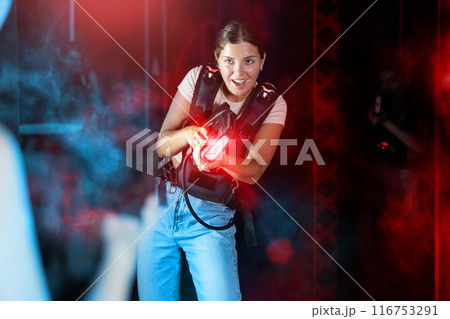 Young lady having fun playing lasertag in labyrinth 116753291