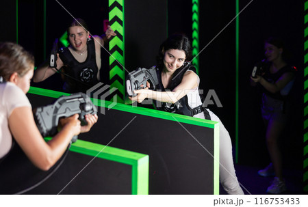 Girls play laser tag, jokingly fight with light weapons Girls play laser tag, jokingly fight with light weapons 116753433