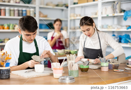 Young woman and young man making pottery 116753663