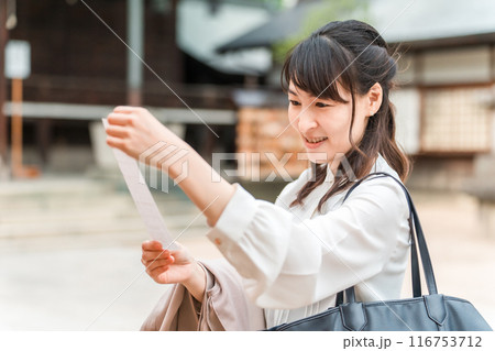 神社でおみくじを引くアジア人女性 116753712
