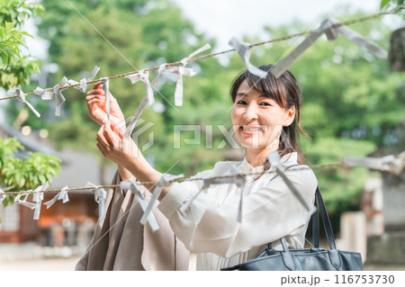 神社でおみくじを引くアジア人女性 116753730