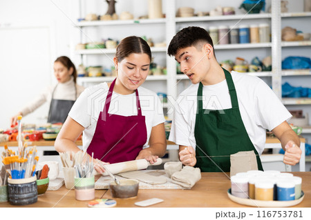 Young woman and young man making pottery Young woman and young man making pottery 116753781