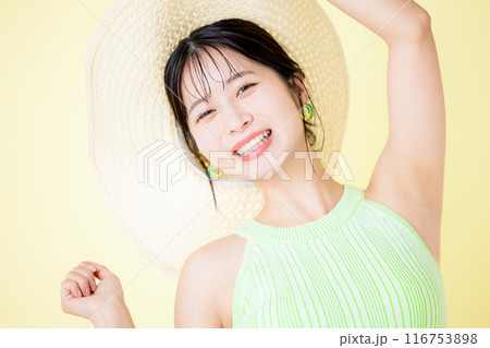夏イメージ　黄色バック　麦わら帽子を持っている若い女性のポートレート 116753898