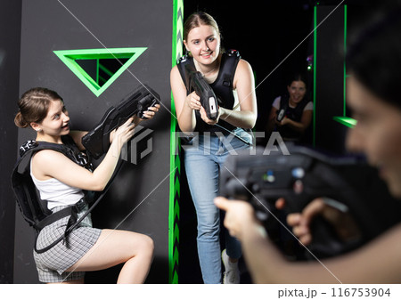 Girls play laser tag, jokingly fight with light weapons Girls play laser tag, jokingly fight with light weapons 116753904