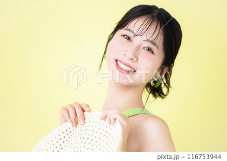 夏イメージ 黄色バック 麦わら帽子を持っている若い女性のポートレート 夏イメージ 黄色バック 麦わら帽子を持っている若い女性のポートレート 116753944