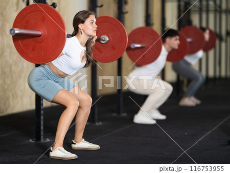 Young woman training with barbell in gym Young woman training with barbell in gym 116753955