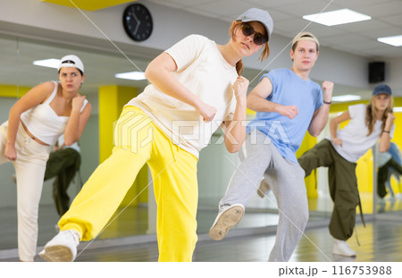 Group of teenagers having dance training in studio, performing contemporary hip hop elements Group of teenagers having dance training in studio, performing contemporary hip hop elements 116753988