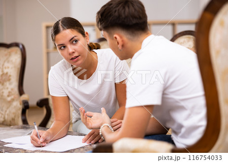 Young family sorting out utility bills together while sitting on sofa Young family sorting out utility bills together while sitting on sofa 116754033