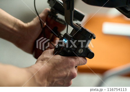 Close-Up of Videographer Operating Gimbal Camera Close-Up of Videographer Operating Gimbal Camera 116754113