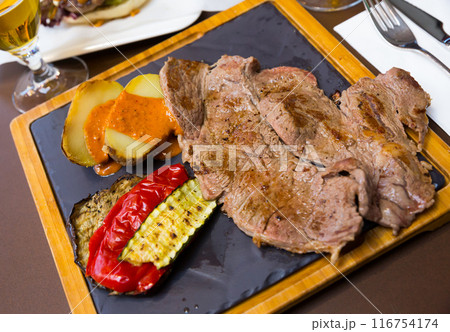 Beef steak with baked potatoes, vegetables, romesco Beef steak with baked potatoes, vegetables, romesco 116754174